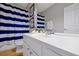 Bathroom with large white vanity and blue and white striped shower curtain at 4816 Tidecrest Ave # 178, Orlando, FL 32819
