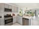 Open-concept kitchen with stainless steel appliances, stylish countertops, and seamless flow to living area at 483 Wayland Dr, Haines City, FL 33844