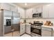 Sleek kitchen featuring stainless steel appliances, gray cabinets, and modern fixtures at 483 Wayland Dr, Haines City, FL 33844