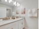 Bright bathroom with dual sinks, framed art, and white cabinets at 4834 Lullaby Ln, Kissimmee, FL 34746