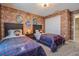 Themed bedroom showcasing two beds, decorative wall emblems, and a charming brick facade at 4834 Lullaby Ln, Kissimmee, FL 34746