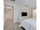 Bright bedroom with a comfortable bed, a TV on a white dresser, and a view of the en-suite bathroom at 4834 Lullaby Ln, Kissimmee, FL 34746