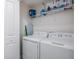 Functional laundry room with a white washer and dryer and convenient overhead storage at 4834 Lullaby Ln, Kissimmee, FL 34746