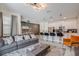 Stylish living room featuring a large sofa, modern lighting, and an open layout to the kitchen and dining area at 4834 Lullaby Ln, Kissimmee, FL 34746
