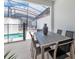 Covered patio with an outdoor dining table and chairs, looking out to a refreshing pool at 4834 Lullaby Ln, Kissimmee, FL 34746