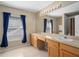 Bright bathroom featuring a double sink vanity, large mirror, and ample natural light from the window at 490 Wekiva Preserve Dr, Apopka, FL 32712