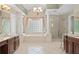 Bright bathroom with a soaking tub and glass shower, framed by elegant columns and stylish fixtures at 490 Wekiva Preserve Dr, Apopka, FL 32712