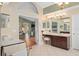 Elegant primary bathroom with double sinks, a seated vanity, and a view of the adjacent bedroom at 490 Wekiva Preserve Dr, Apopka, FL 32712