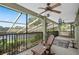 Enjoy the serene view from this screened-in patio with a ceiling fan and comfortable rocking chairs at 490 Wekiva Preserve Dr, Apopka, FL 32712