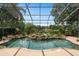 A stunning screened-in pool area with a spa, rock features, lush landscaping, and serene lake views at 490 Wekiva Preserve Dr, Apopka, FL 32712