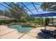 Enclosed screened pool area with lush tropical landscaping, rock waterfall, and comfortable lounge chairs at 490 Wekiva Preserve Dr, Apopka, FL 32712