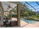 This screened-in pool area has patio seating and a rock waterfall feature for a peaceful tropical environment at 490 Wekiva Preserve Dr, Apopka, FL 32712