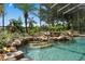 A screened-in pool features rock accents and lush landscaping, creating a private backyard oasis at 490 Wekiva Preserve Dr, Apopka, FL 32712