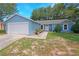 Charming one-story home with blue exterior, well-maintained landscaping, and a two car garage at 5032 Timber Ridge Trl, Ocoee, FL 34761