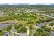 Aerial view of a residential community with houses, trees, and a pond at 608 Ashwell Ct, Debary, FL 32713