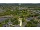 Aerial view of home in a tranquil neighborhood with mature trees, and a nearby pond at 608 Ashwell Ct, Debary, FL 32713