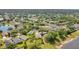 Areal view of neighborhood showcasing lush trees, well-manicured lawns, and a tranquil lake at 608 Ashwell Ct, Debary, FL 32713
