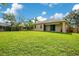 Back yard with lush green grass and wood fence under a blue sky with clouds at 608 Ashwell Ct, Debary, FL 32713