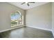 Minimalist bedroom with gray wood floors, neutral walls, and arched window at 608 Ashwell Ct, Debary, FL 32713