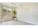 Simple bedroom with neutral walls, gray floors, ceiling fan and bright window at 608 Ashwell Ct, Debary, FL 32713
