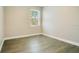 Empty bedroom with wood-look floors, a window and neutral colored walls at 608 Ashwell Ct, Debary, FL 32713