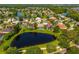 Aerial view of home with a screened-in pool, surrounded by pond and lush landscaping at 641 Lakescape Ct, Orlando, FL 32828