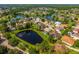 Aerial view of home with pond, screened-in pool, and manicured lawns in a suburban neighborhood at 641 Lakescape Ct, Orlando, FL 32828