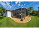 Backyard view with a screened-in patio featuring outdoor seating and a well-maintained lawn at 641 Lakescape Ct, Orlando, FL 32828