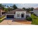 A bright, white single-story home with a two-car garage and charming arched entryway at 641 Lakescape Ct, Orlando, FL 32828