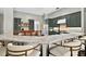 A modern kitchen features a marble island with seating, dark green cabinets and stainless-steel appliances at 641 Lakescape Ct, Orlando, FL 32828