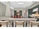 Bright kitchen boasts stone counters, dark green cabinets, stainless-steel appliances, and an island with comfortable seating at 641 Lakescape Ct, Orlando, FL 32828