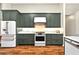 Modern kitchen featuring green cabinets, stainless steel appliances, and granite countertops at 641 Lakescape Ct, Orlando, FL 32828