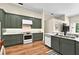 Well-equipped kitchen featuring green cabinets, granite countertops, and stainless steel appliances at 641 Lakescape Ct, Orlando, FL 32828