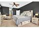 A neutral-toned main bedroom featuring a ceiling fan and a sitting area with an adjacent ensuite bathroom at 641 Lakescape Ct, Orlando, FL 32828