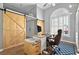 Well-lit home office with a large window and stylish sliding barn doors at 641 Lakescape Ct, Orlando, FL 32828