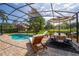Screened in pool featuring brick pavers, lounge chairs, and a table with seating at 641 Lakescape Ct, Orlando, FL 32828