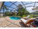 Inviting screened-in pool with lounge chairs on a brick patio and manicured landscaping at 641 Lakescape Ct, Orlando, FL 32828