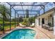 Screened in pool featuring brick pavers, lounge chairs, and a view of the water at 641 Lakescape Ct, Orlando, FL 32828