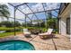 Screened in pool featuring brick pavers, lounge chairs, and a table with seating at 641 Lakescape Ct, Orlando, FL 32828