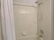 Shower tiled in white, with a shower head, controls, and soap shelf at 641 Lakescape Ct, Orlando, FL 32828