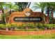 Close-up of the 'Waterford Reserve' brick community sign, surrounded by green shrubbery and small American flags at 641 Lakescape Ct, Orlando, FL 32828