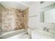 Bathroom featuring a shower with earth-toned tiles, a toilet, and a vanity with sink at 657 Mckinley Ct, Kissimmee, FL 34758