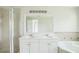 Bathroom featuring double vanity sinks, large mirror and walk-in shower at 657 Mckinley Ct, Kissimmee, FL 34758