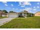 Charming single-story home with white exterior, attached garage and well-manicured lawn at 657 Mckinley Ct, Kissimmee, FL 34758
