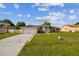 View of white single-story home featuring an attached garage at 657 Mckinley Ct, Kissimmee, FL 34758