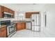 Bright kitchen with stainless steel appliances, granite countertops, and tiled flooring at 657 Mckinley Ct, Kissimmee, FL 34758
