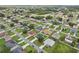 An aerial view capturing a residential neighborhood with tree-lined streets and well-maintained homes at 670 Bluebill Ct, Poinciana, FL 34759