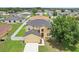 Overhead view of a two-story home with a well-manicured lawn and long driveway at 670 Bluebill Ct, Poinciana, FL 34759