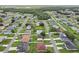 Neighborhood aerial view of single Gathering homes showing lawns and tree lined streets on a sunny day at 670 Bluebill Ct, Poinciana, FL 34759