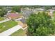 Aerial view of a yellow home, surrounded by mature trees, a fenced yard and extended driveway at 670 Bluebill Ct, Poinciana, FL 34759